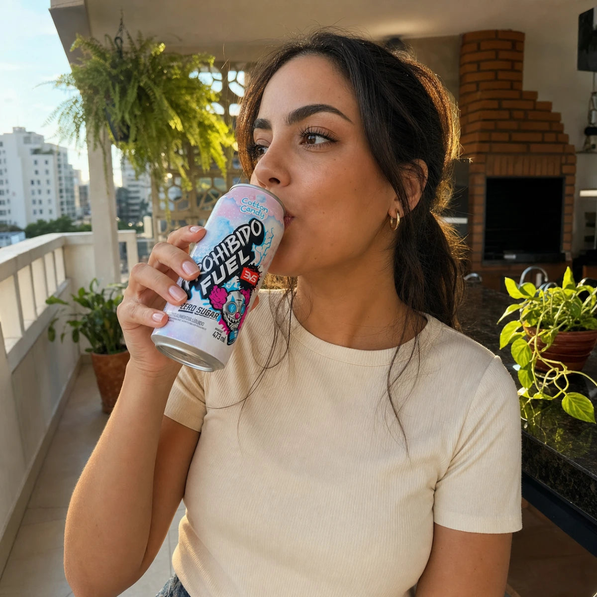 Mulher brasileira tomando Prohibido Fuel Cotton Candy 473ml em varanda de condomínio