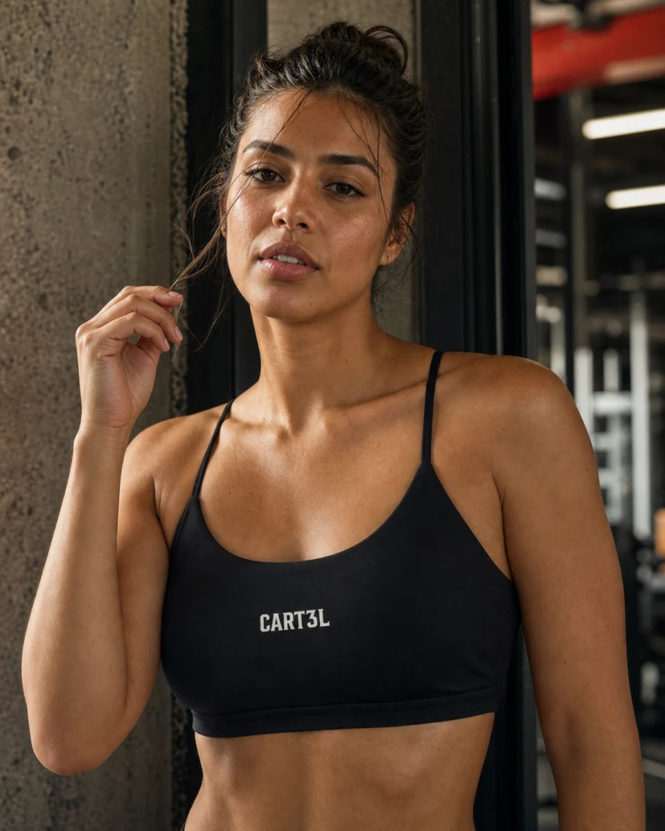 Atleta brasileira usando top fitness preto Cart3l com alças finas e logo frontal