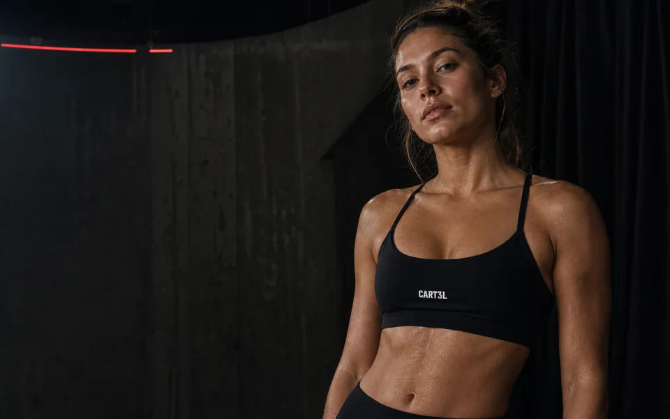 Atleta usando top preto Cart3l representando a moda fitness 3VS